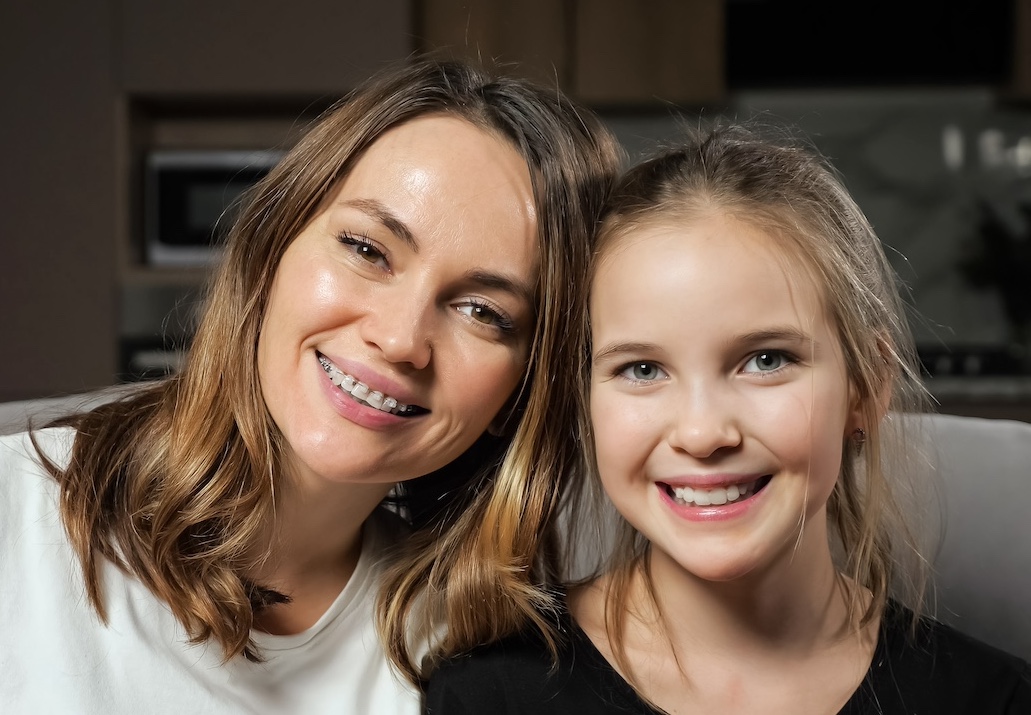 mom with braces and daughter smiling