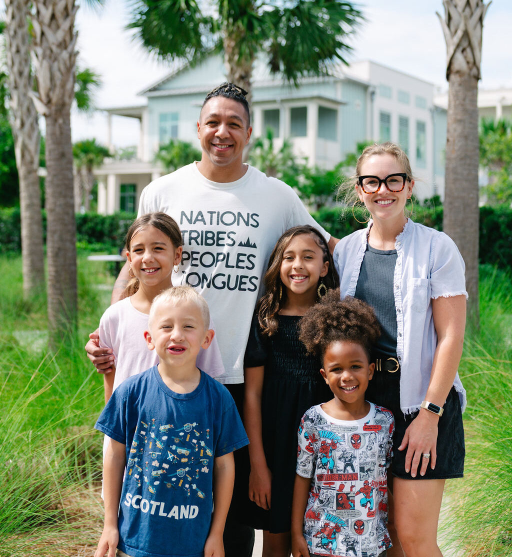 Patient family of Bocklet Orthodontics, mom, dad, and four young children, smiling outside in Charleston